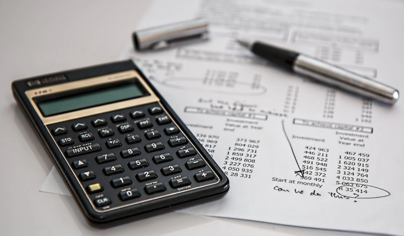 calculator, pen, and sheet on the table