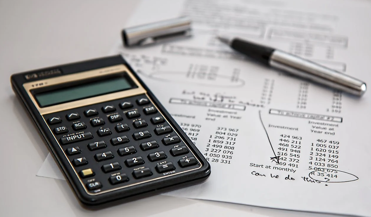 calculator, pen, and sheet on the table