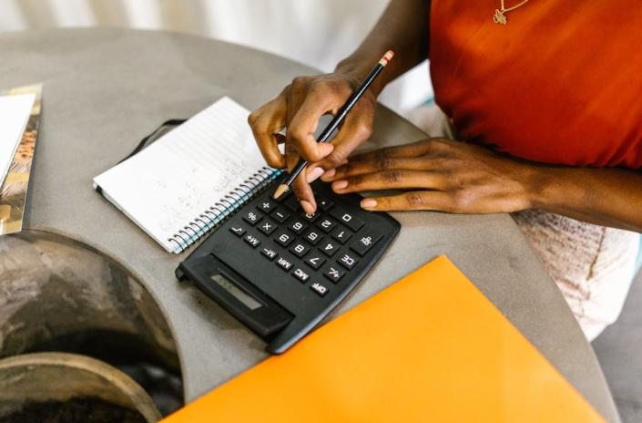 a woman sits at a desk in the office, calculates and makes notes